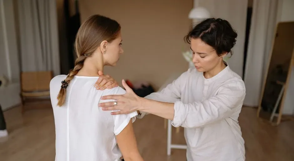 A female therapist checking a clothed client's posture