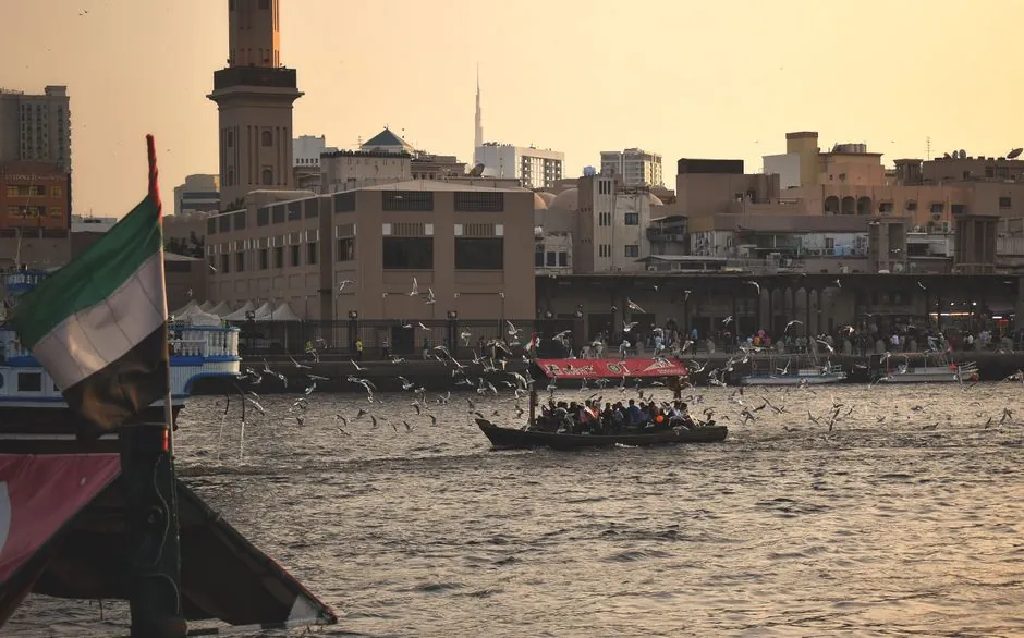 An abra crossing Dubai Creek at sunset in the old town. The same Creek runs past Al Jaddaf further upstream