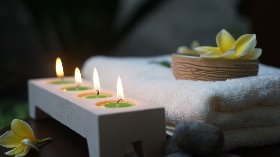 Spa candles and folded towels in a calm massage setting